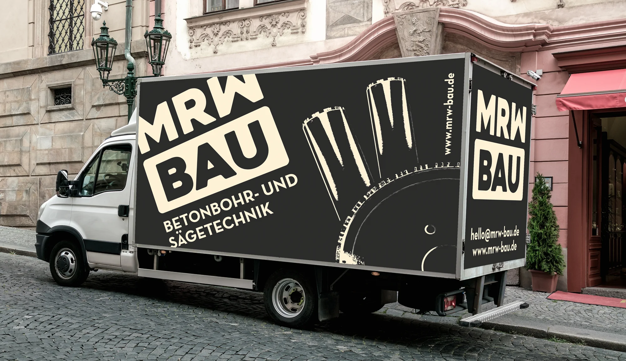Transporter der MRW Bau GmbH mit auffälliger Fahrzeugbeschriftung und Folierung im Corporate Design